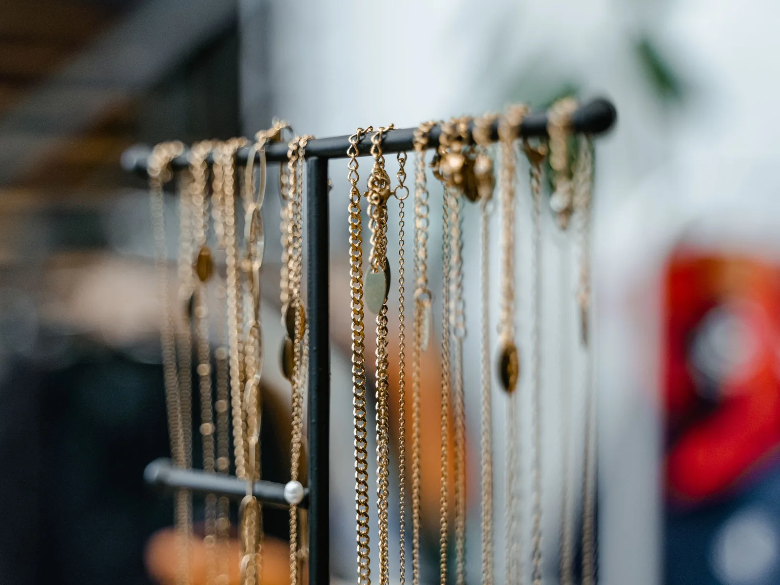 Gold necklaces hanging separately on a jewelry stand